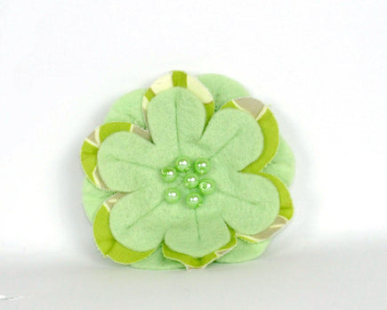 Apple green soft felt flower brooch with printed cotton inset petals and pearl beads at the centre. 