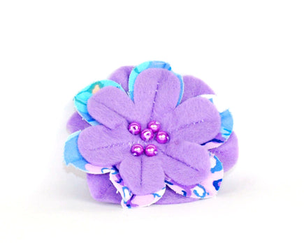 Lilac soft felt flower brooch with lilac & blue printed cotton inset petals. Lilac pearl beads at the centre. 
